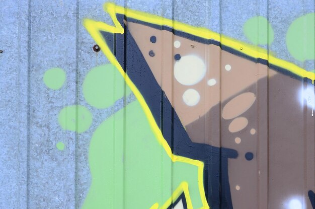Photo fragment de dessins de graffitis le vieux mur décoré de taches de peinture dans le style de la culture de l'art de rue texture de fond colorée