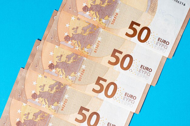Photo fragment du billet de cinquante euros sur fond bleu.