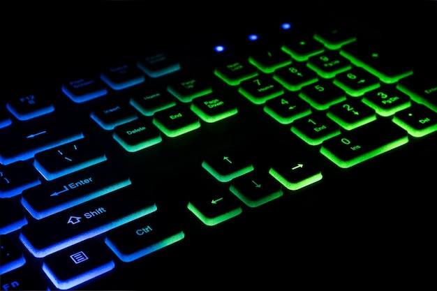 Photo fragment du clavier de jeu avec rétroéclairage couleur sur fond noir gros plan du clavier de l'ordinateur