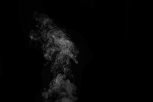 Fragment de fumée de vapeur bouclée chaude blanche isolée sur fond noir, gros plan. Créez des photos mystiques. Abstrait, élément de conception