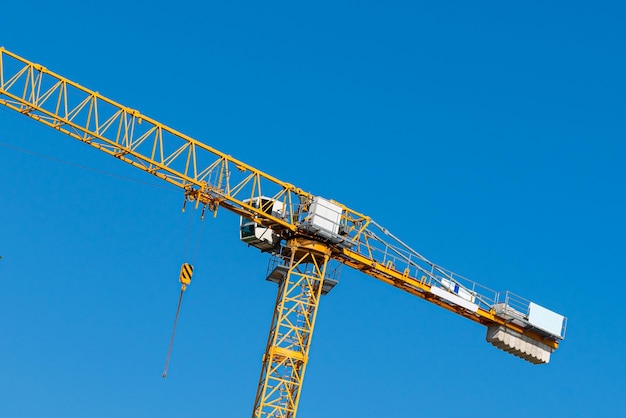 Fragment d'une grue jaune contre le ciel bleu