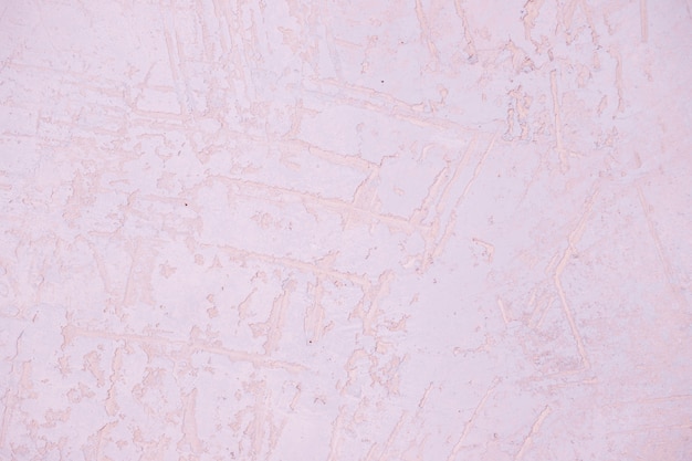 Fragment de mur avec des rayures et des fissures Texture de mur en plâtre rose clair. Mur pastel. Surface du mur peint abstrait. Mur de stuc avec espace de copie pour la texture de la surface du mur design.concrete