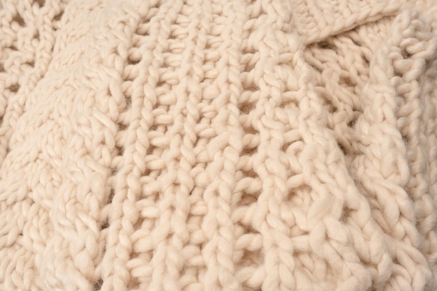 Un fragment de tricot beige tricoté à partir de laine de mouton blanche