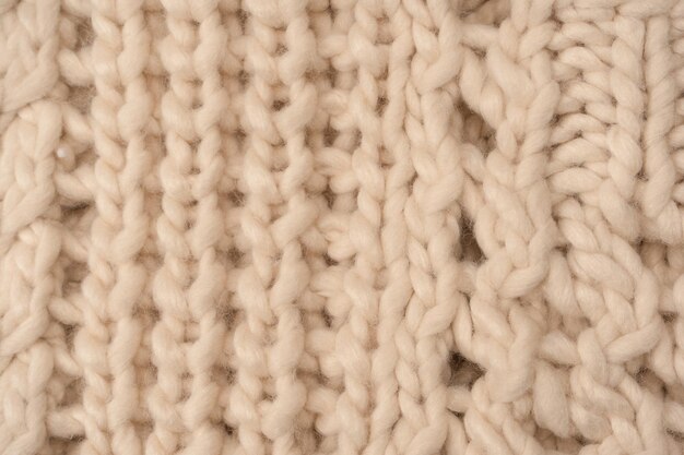 Un fragment de tricot beige tricoté à partir de laine de mouton blanche