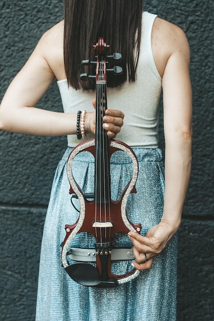 Un fragment d'un violon électrique un violon entre les mains de la fille d'un musicien