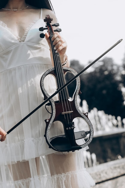 Un fragment d'un violon électrique un violon entre les mains de la fille d'un musicien