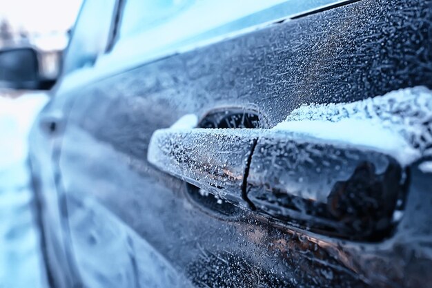 Fragment d'une voiture en hiver dans la ville de décembre de fond de givre