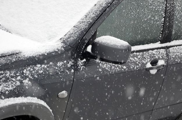 Fragment de la voiture sous une couche de neige après une forte chute de neige.