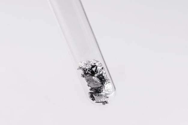 Fragments de chrome à l'intérieur du tube à essai à usage industriel minerai élément chimique métallique isolé sur fond blanc