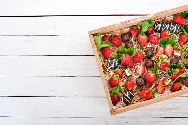 Fraise au chocolat dans une boîte en bois Sur un fond en bois Vue de dessus Espace de copie