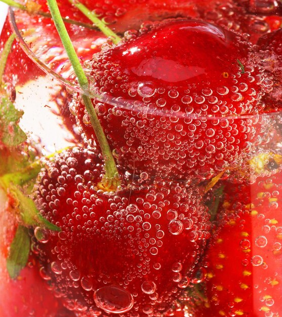 une fraise avec de l'eau et une tige dedans
