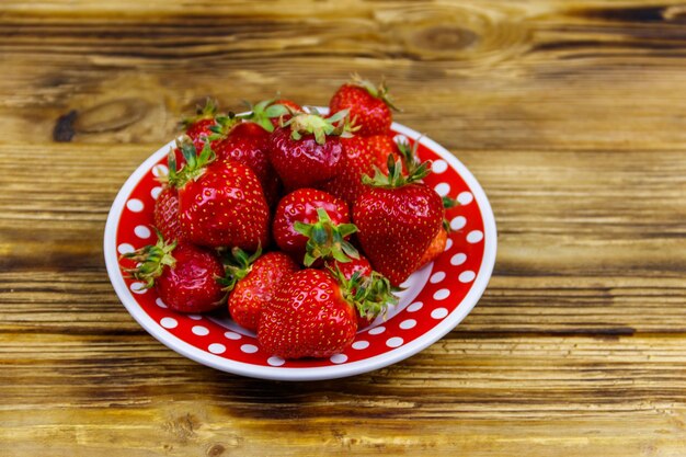 Fraise fraîche dans une assiette sur une table en bois