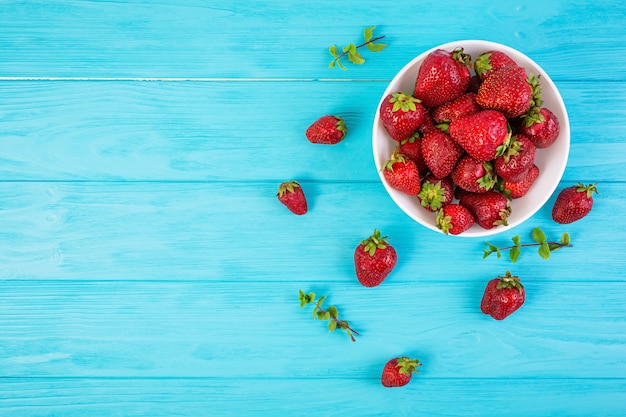 Fraise fraîche dans un bol sur fond de bois