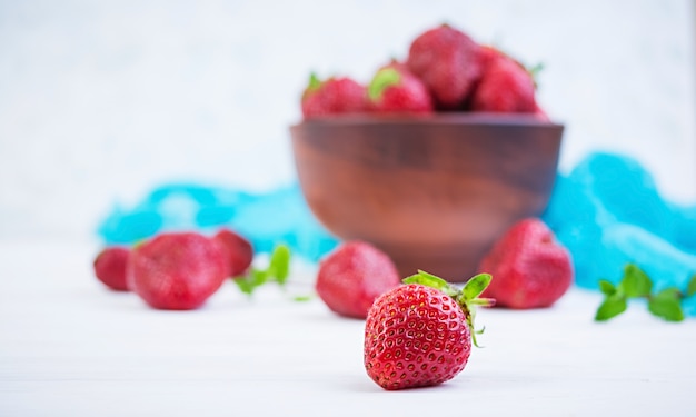 Fraise fraîche dans un bol sur fond de bois