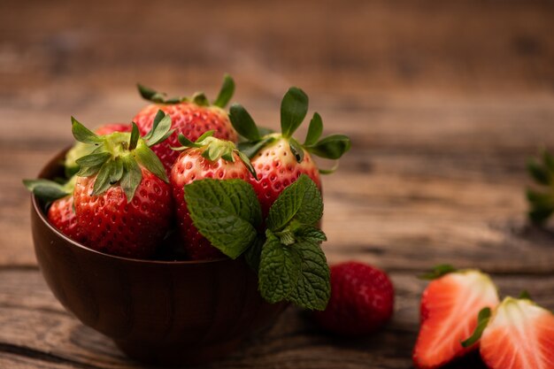 Fraise fraîche dans un panier sur une table rustique en bois, gros plan