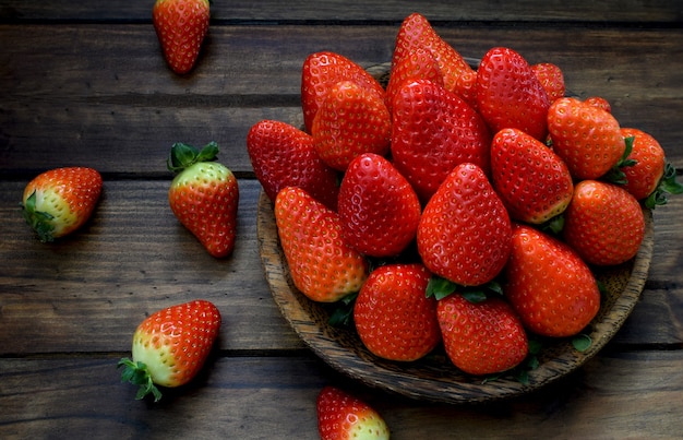 Fraise fraîche dans une plaque en bois sur fond en bois