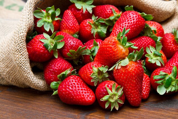 Fraise fraîche dans un sac de jute sur bois