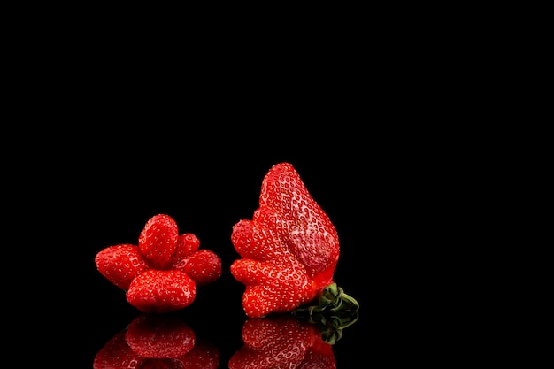 Fraise moche sur fond noir libre de fraises biologiques inhabituelles