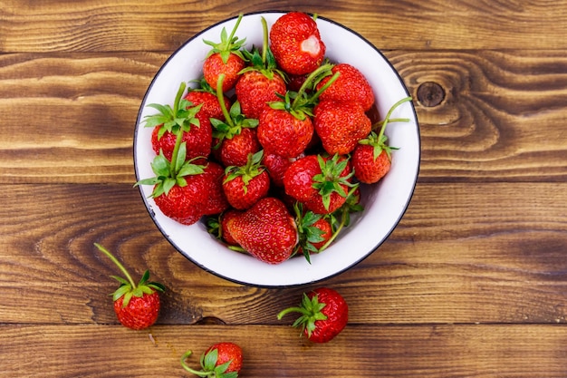 Fraise mûre fraîche dans un bol blanc sur une table en bois Vue de dessus