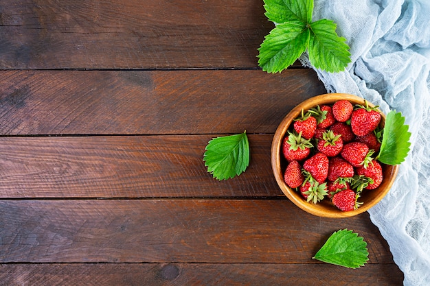 Fraise mûre fraîche douce isolée sur fond en bois.