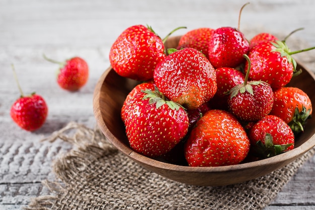 Fraise mûre fraîche sur un fond de table en bois