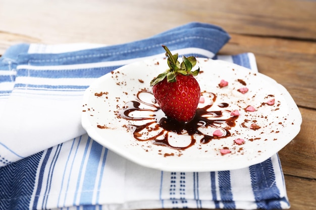 Fraise mûre rouge avec du chocolat sur une table en bois