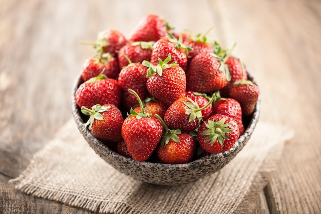 Fraise rouge dans un bol sur table en bois