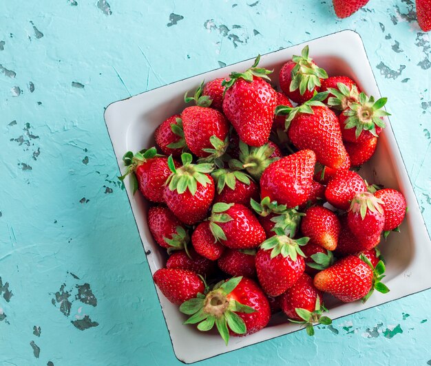 Fraise rouge mûre dans une assiette carrée blanche