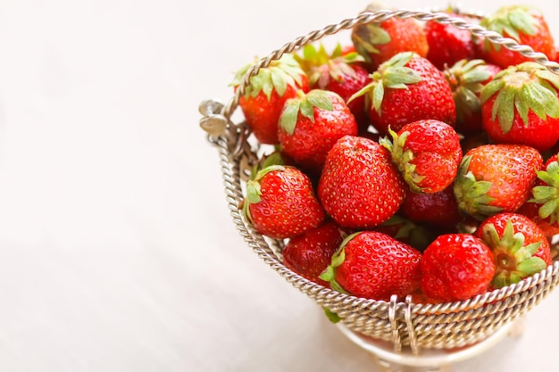 Fraise rouge mûre dans le panier en osier sur la nappe en lin