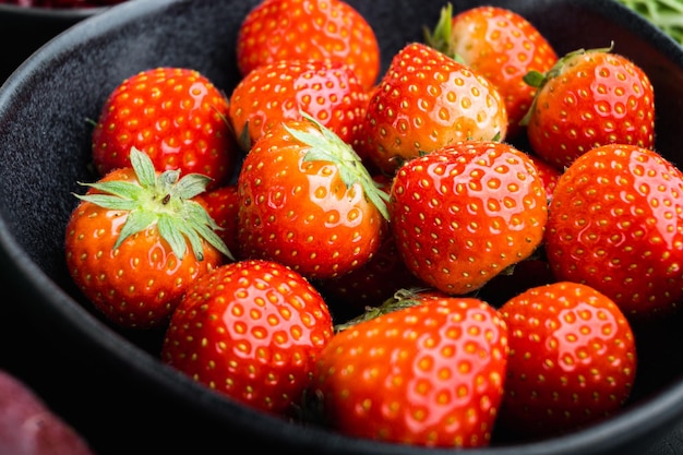 Fraise rouge mûre sur fond de bois foncé.