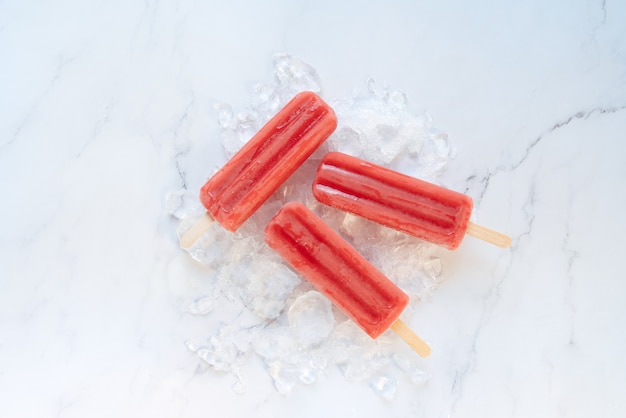 La fraise saute sur une table de marbre et de glace