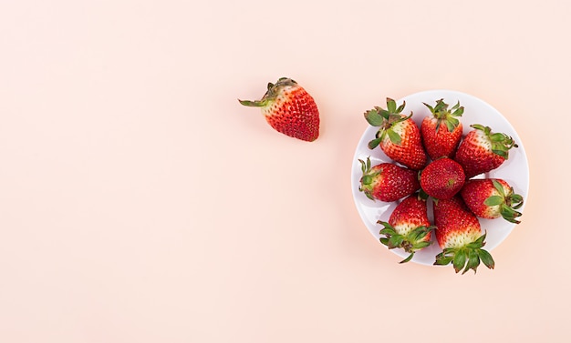 Fraise sucrée sur fond rose. Vue de dessus. Lay plat.