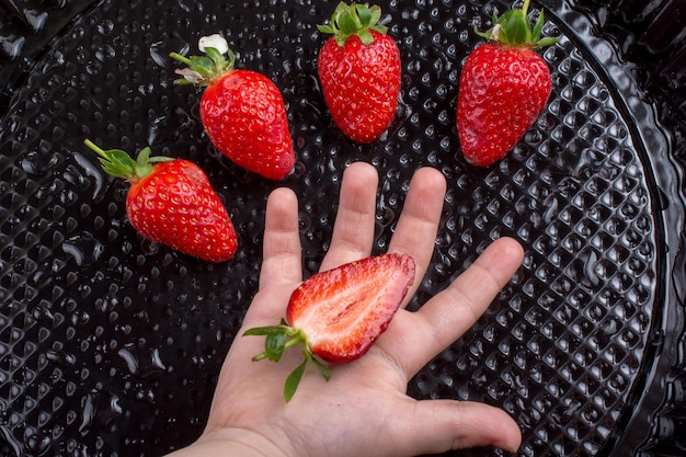 Fraise sucrée et mûre à la main