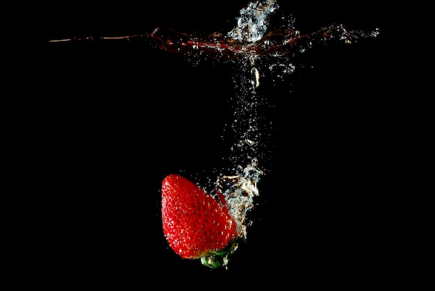 Photo fraise tombant dans l'eau