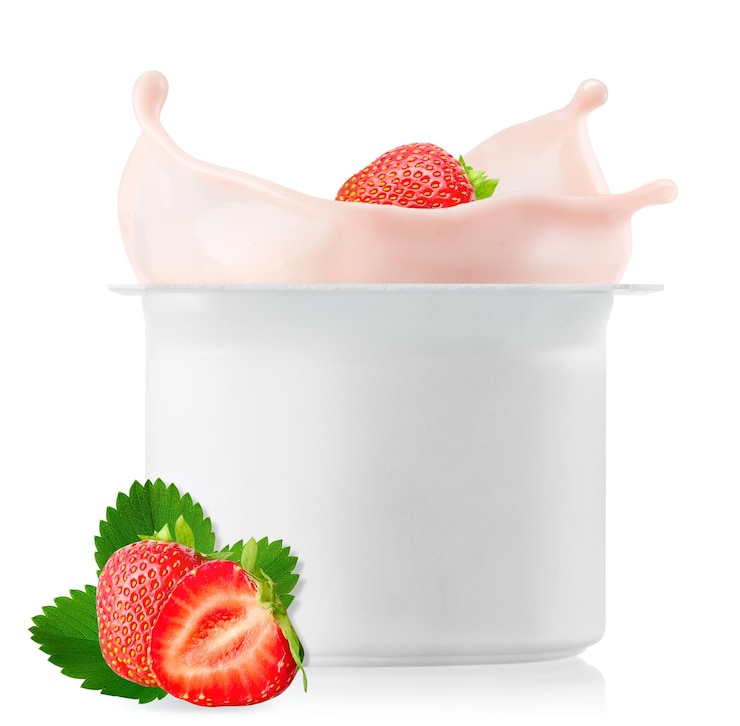 Photo fraise tombant dans une tasse en plastique avec du yogourt