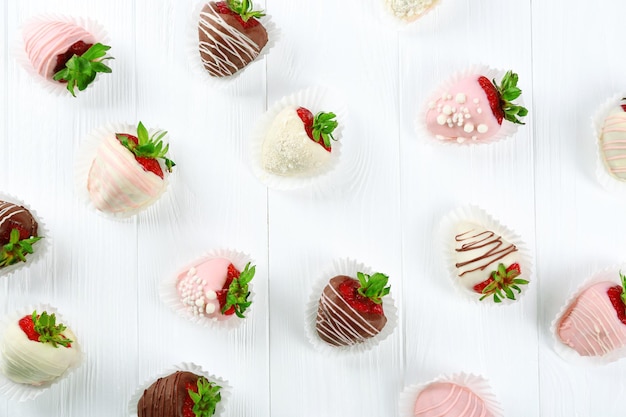 Fraises au chocolat différent sur fond de bois clair