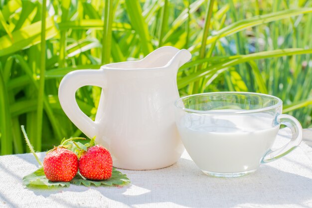 Fraises, baies, feuilles, pichet, tasse, lait, serviette, fond herbe