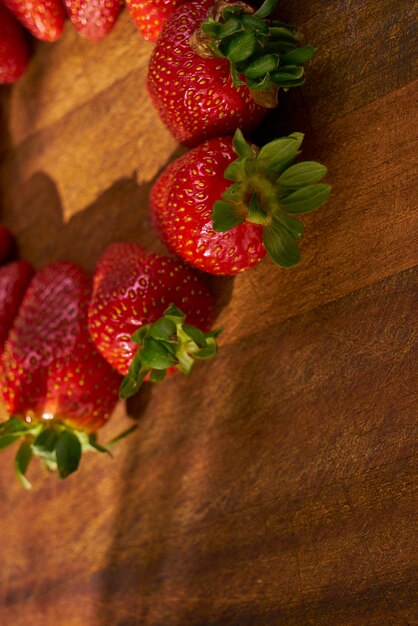 Fraises biologiques fraîches sur une planche à découper en bois