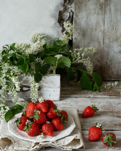 Fraises biologiques juteuses sur une vieille table texturée en bois