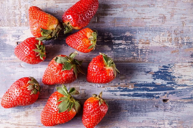 Fraises biologiques mûres sur fond en bois