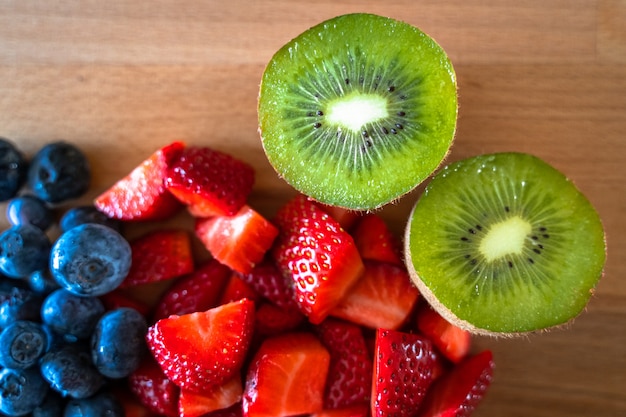 Fraises, bleuets et kiwis dans une table en bois