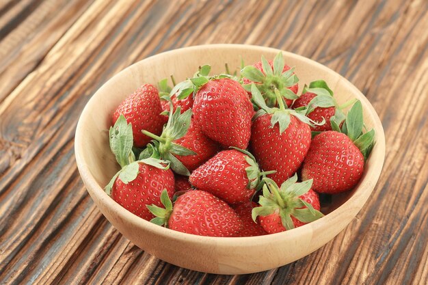 Des fraises sur un bol en bois