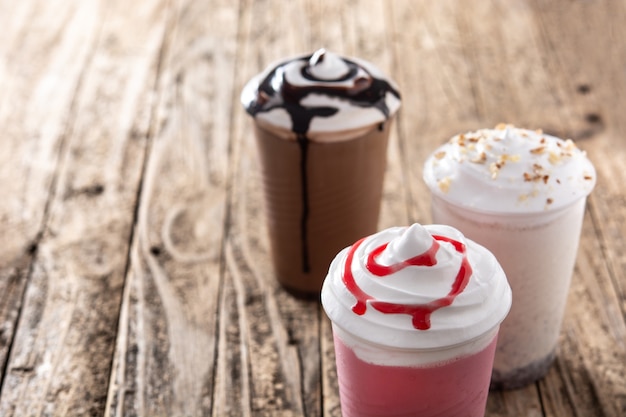 Fraises, chocolat et milkshakes glacés blancs sur table en bois