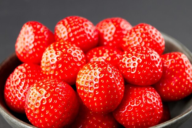 Fraises dans un bol. Fond noir. Prise de vue en studio