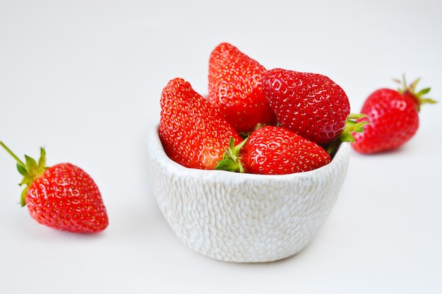 Photo fraises dans un bol isolé sur blanc