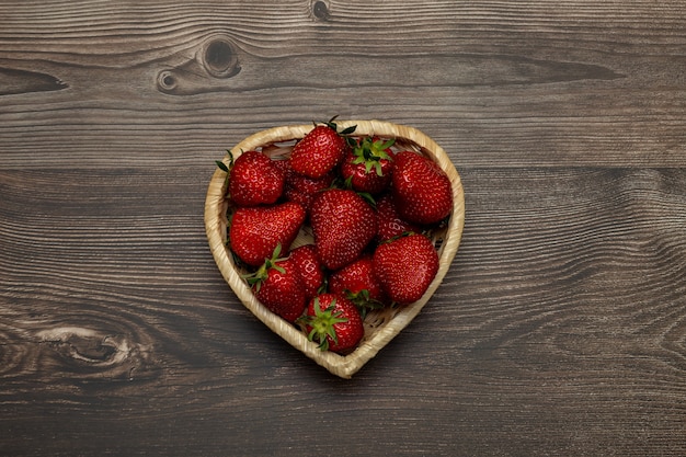 Fraises dans un panier sur une table en bois marron