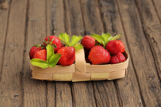 Fraises dans un panier sur un vieux style rétro rustique de fond en bois minable