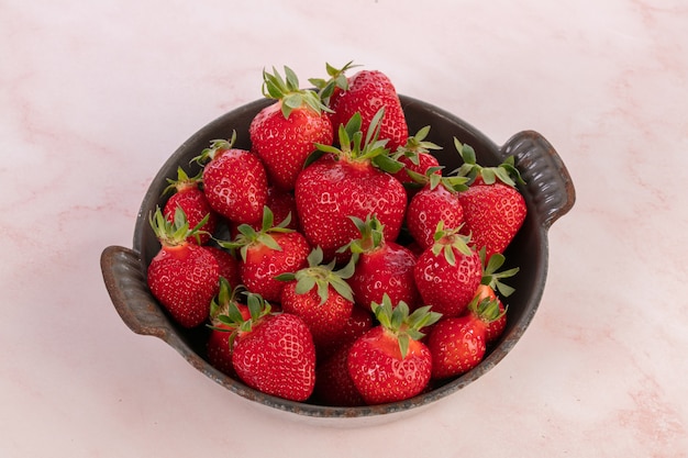 Fraises dans un vieux plat émaillé gris sur rose