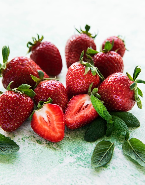 Fraises délicieuses mûres fraîches sur un fond en bois vert