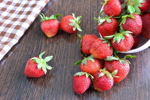 fraises dispersées sur une table du bol rose